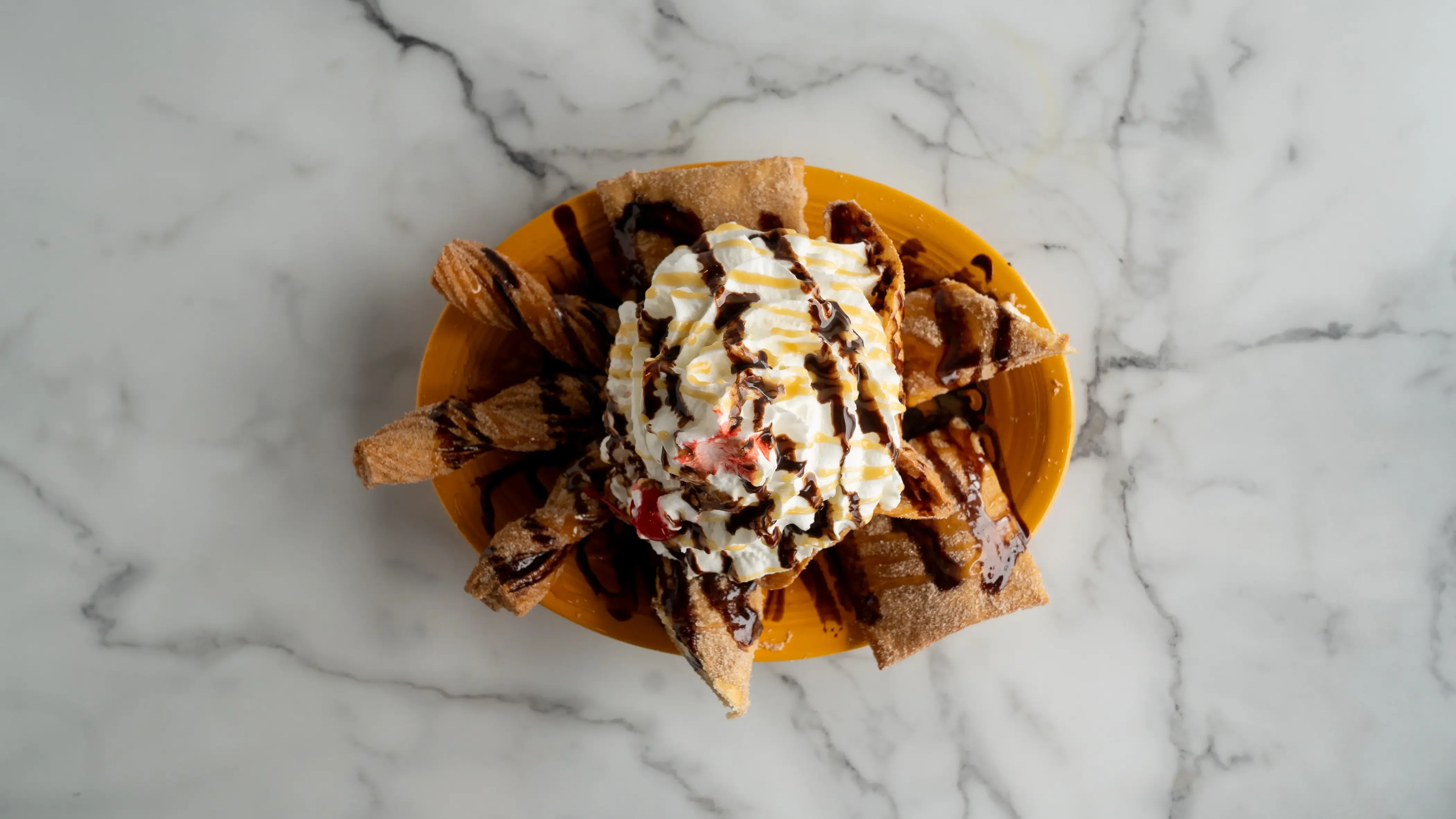 Traditional Mexican desserts featuring cinnamon sugar churros with chocolate sauce and creamy flan